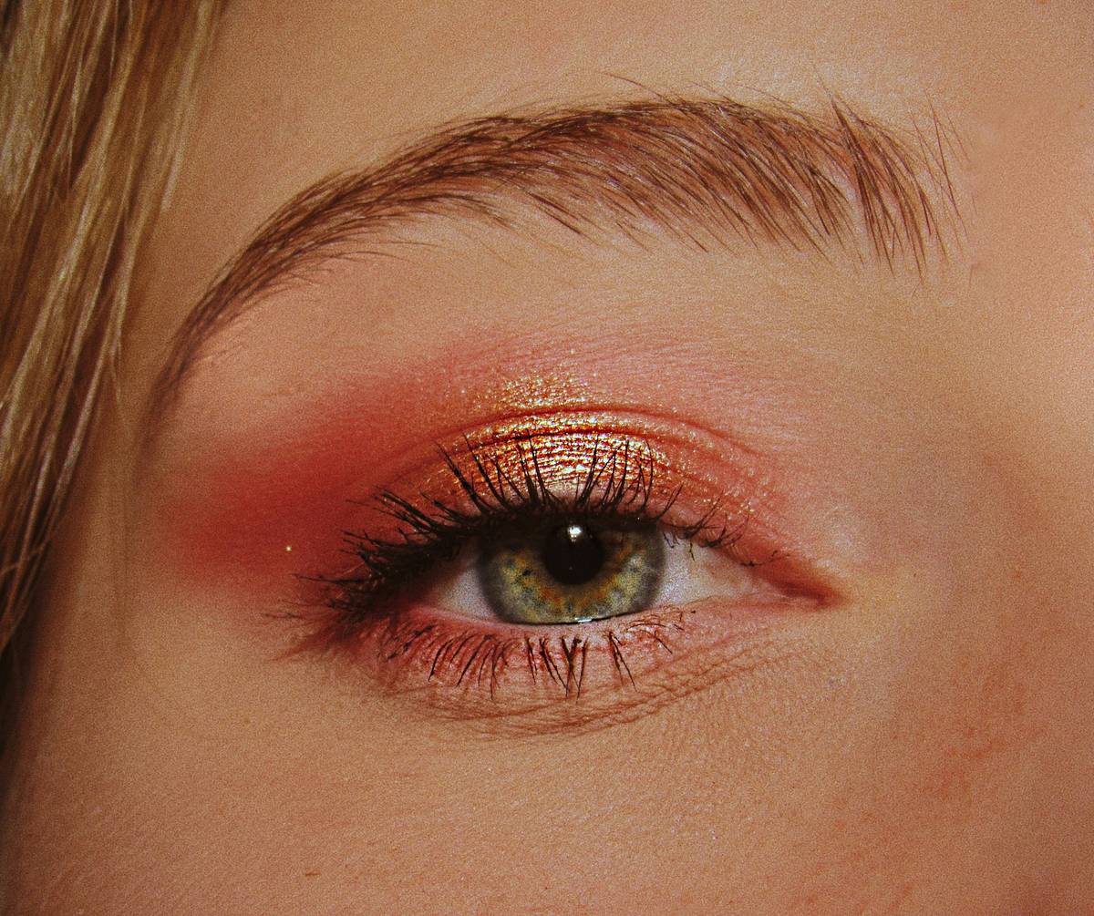 Professional makeup artist applying multi-effect palette shades across eyes and cheeks